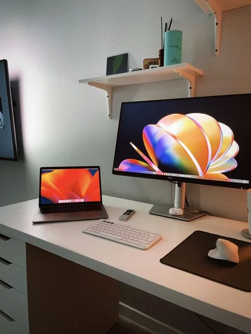 A modern workspace featuring dual computer monitors displaying web design projects, emphasizing technology and productivity.